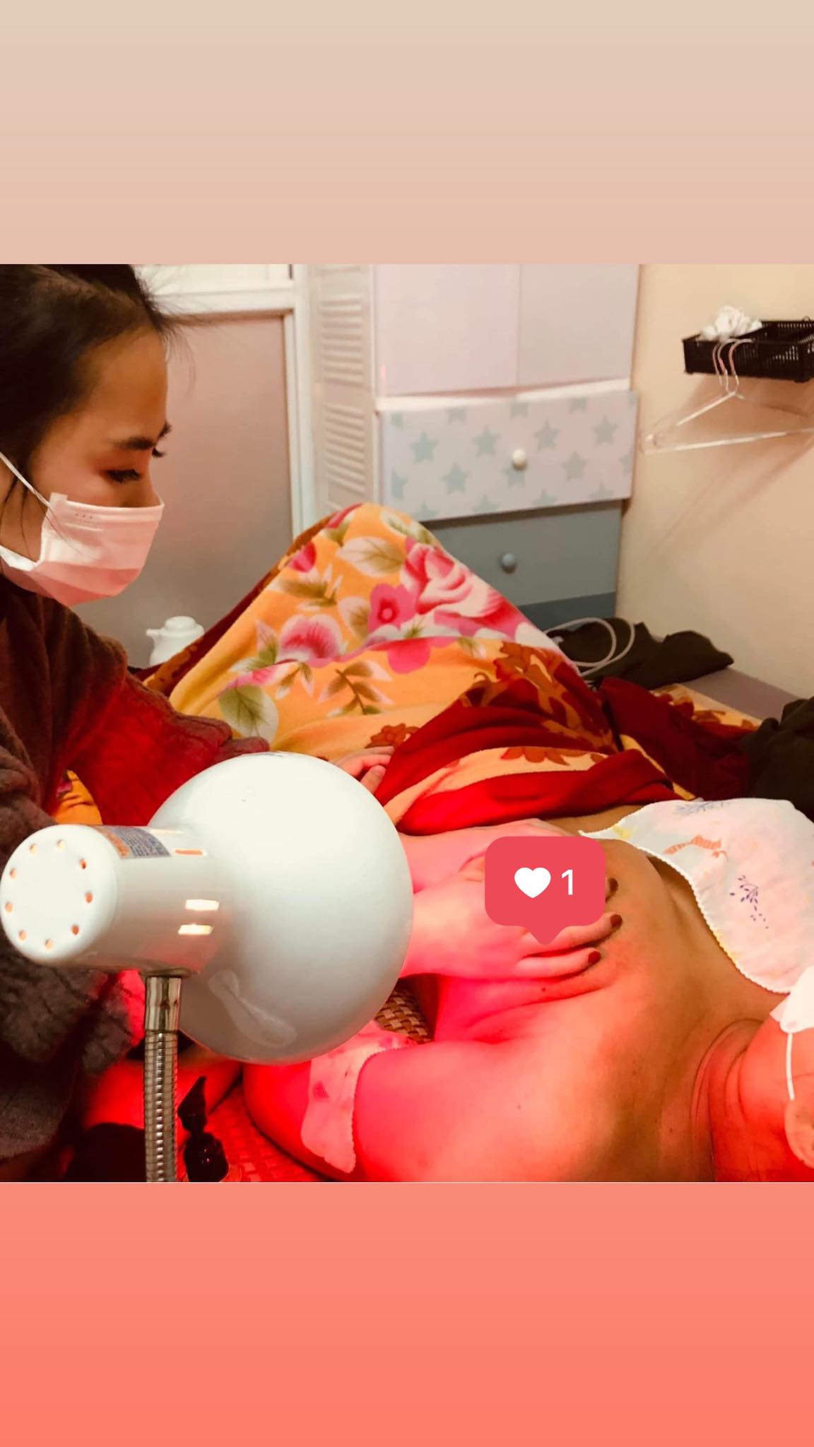 Kỹ thuật viên EmeCare chiếu đèn hồng ngoại trong một buổi chăm sóc mẹ